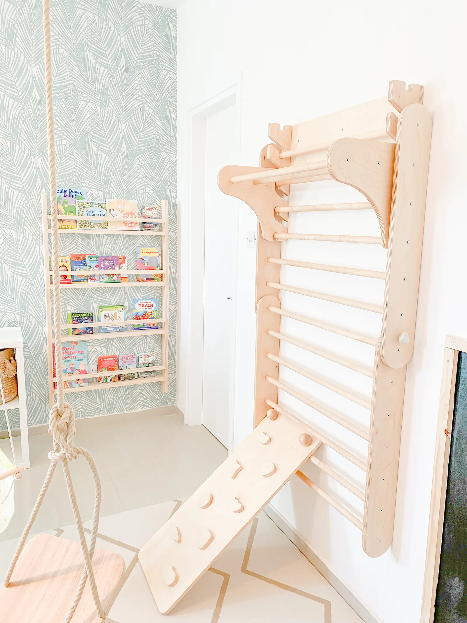 A children's room with a climbing wall and book shelves