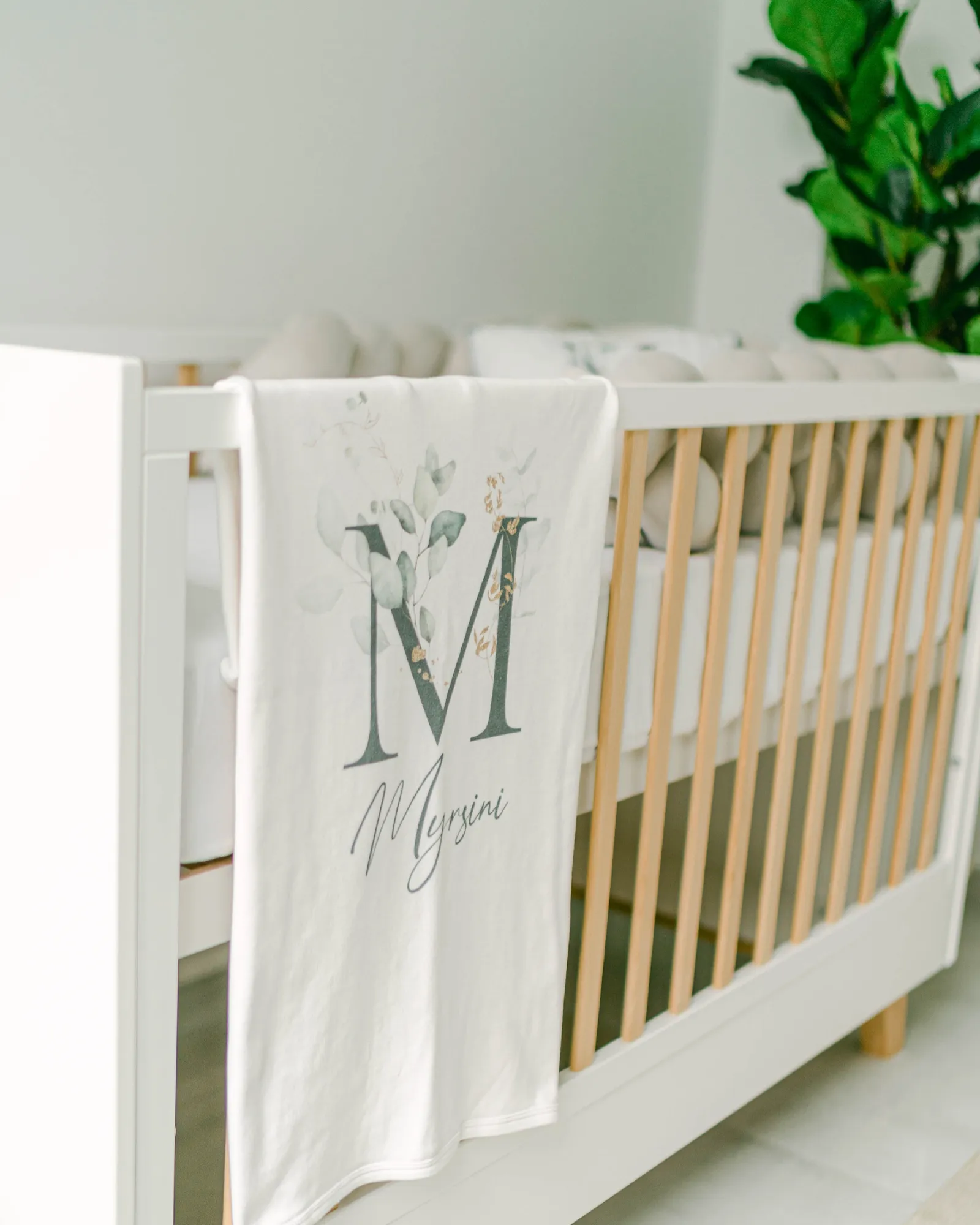 A baby nursery cot with a personalised blanket
