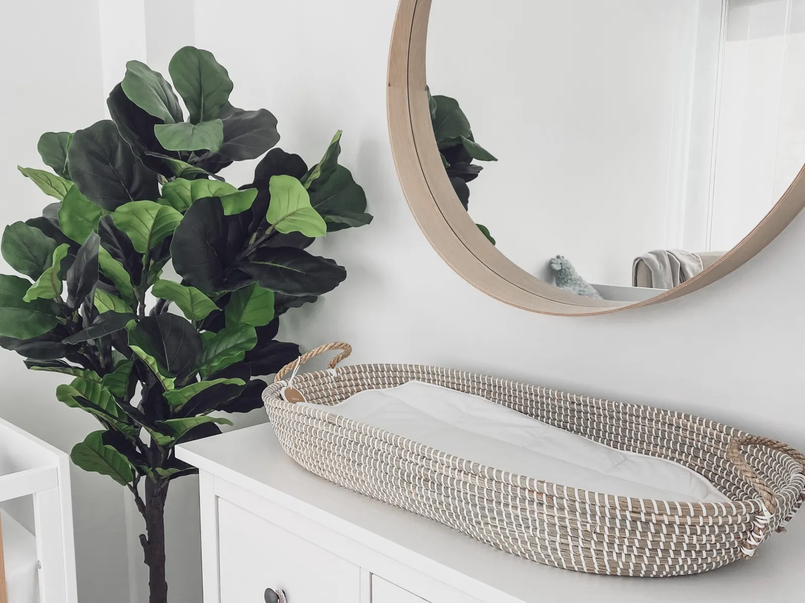 A baby changing basket on a dresser in a nursery designed by Meraki Moraki